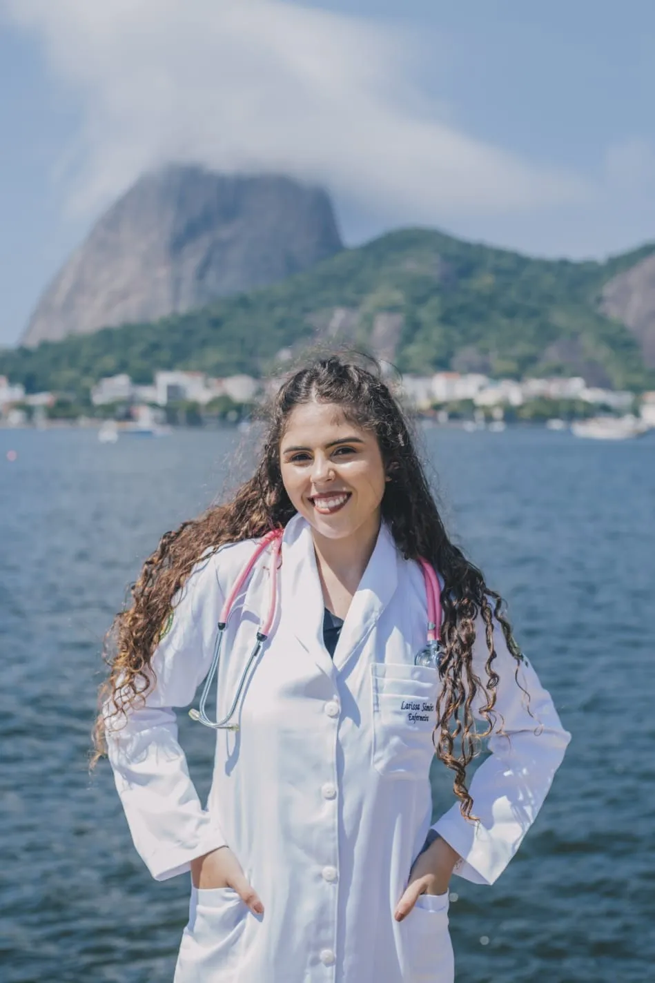 Larissa Simões de jaleco, com o Pão de Açúcar ao fundo