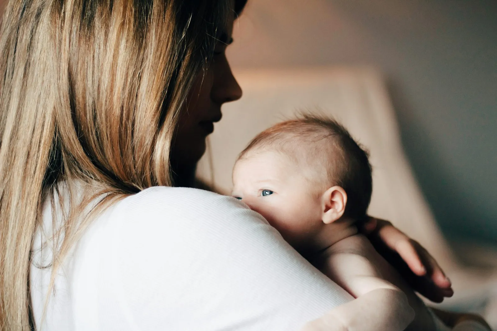 Mãe segurando o bebê recém-nascido junto ao peito